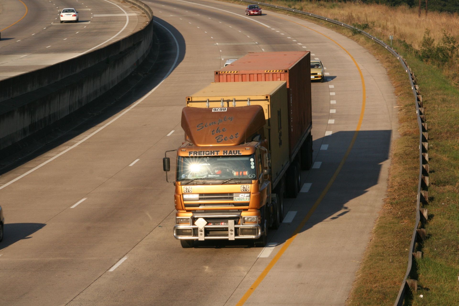 Container truck driving on a curving highway