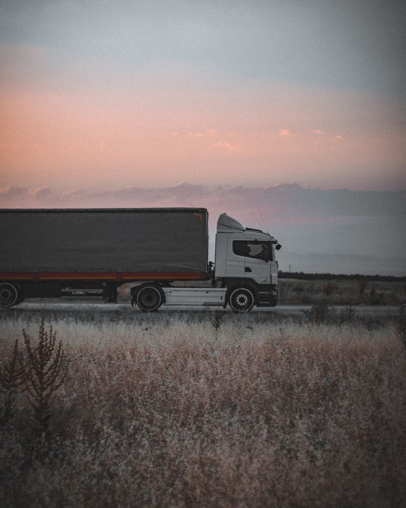 Trailer truck on an open road at dusk